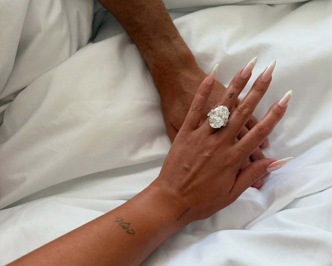 Imagen donde se muestra la mano de un hombre y mujer, ella luciendo un anillo de compromiso de color blanco con un Diamante en corte ovalado.