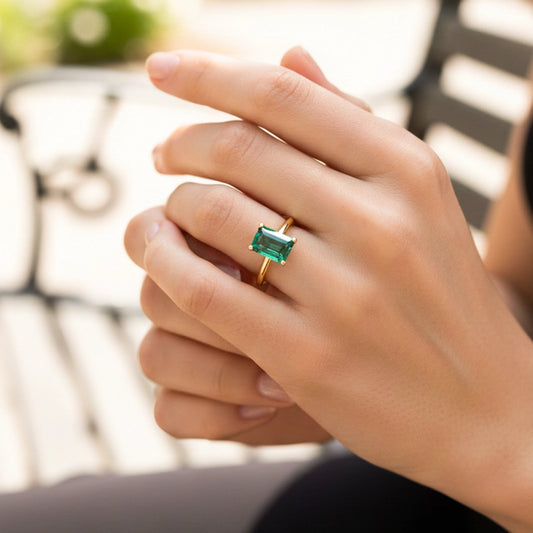 Mano de una modelo usando un anillo en oro amarillo con Esmeralda de laboratorio de Joyería Caracas.