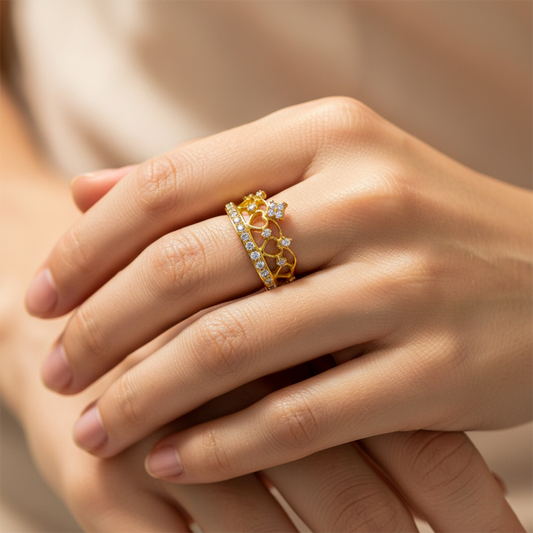 Mano de mujer usando un anillo con forma de corazón en oro amarillo de 18 quilates con cristales de color blanco de Joyería Caracas.