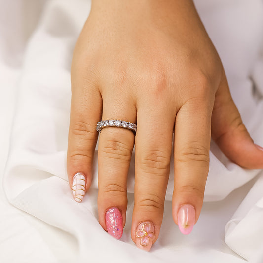 Mano de mujer con anillo en oro blanco de 18 quilates con cristales de color blanco alrededor, fabricada en Joyería Caracas.