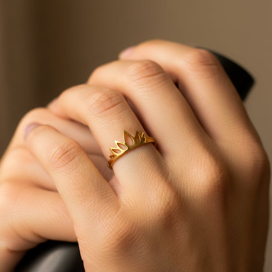 Mano de mujer usando un anillo con forma de corona en oro amarillo de 8 quilates de Joyería Caracas.