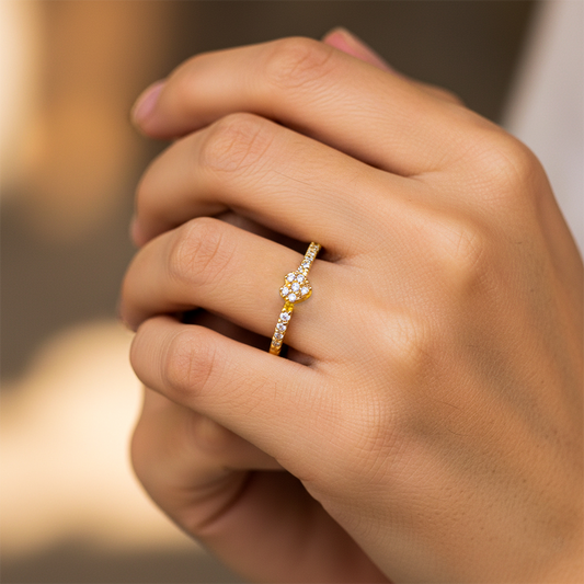 Mano de mujer usando un anillo con forma de corazón en el centro con cristales de color blanco de Joyería Caracas.