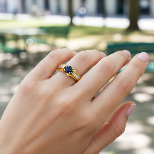Mano de modelo usando un anillo en oro amarillo de 18 quilates con Zafiro y Diamantes de Joyería Caracas.