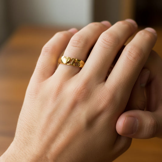 Mano de mujer usando un anillo con forma de corazón y el número 15 en el centro en oro amarillo de 18 quilates de Joyería Caracas.