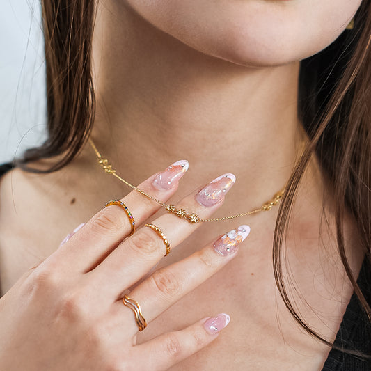 Mujer usando anillo con forma de corazones en oro amarillo de 18 quilates.