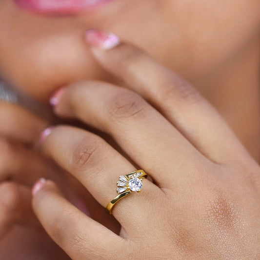 Mano de mujer usando un anillo solitario en oro de 18 quilates con cristal en el centro, en el lateral y en forma de trapecios de color blanco de Joyería Caracas.