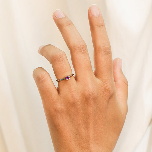 Mano de mujer con anillo en oro blanco de 18 quilates con piedra en el centro Amatista de color morado, fabricado en Joyería Caracas.