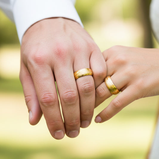 Manos de una pareja usando unas argollas en oro amarillo de 18 quilates de Joyería Caracas.
