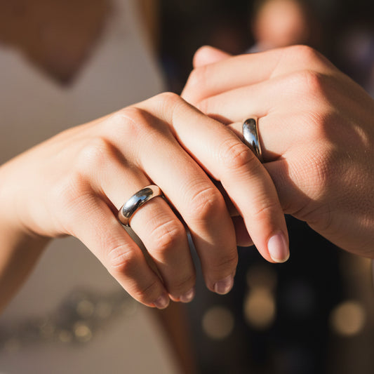 Manos de una pareja usando unas argollas de matrimonio en oro blanco de 18 quilates de Joyería Caracas.
