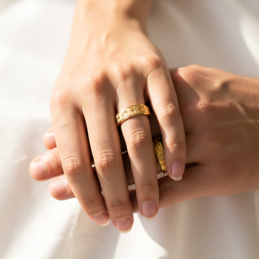 Manos de una pareja usando unas argollas en oro amarillo de 18 quilates de Joyería Caracas.