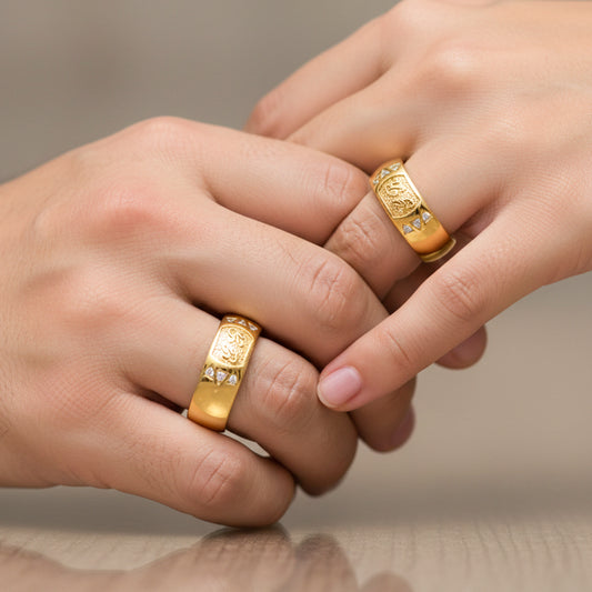 Manos de una pareja usando unas argollas en oro amarillo de 18 quilates personalizadas con cristales de Joyería Caracas.