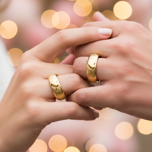 Manos de una pareja usando unas argollas en oro amarillo de 18 quilates de Joyería Caracas.