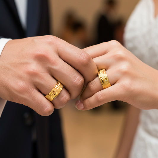 Manos de una pareja usando unas argollas en oro amarillo de 18 quilates de Joyería Caracas.