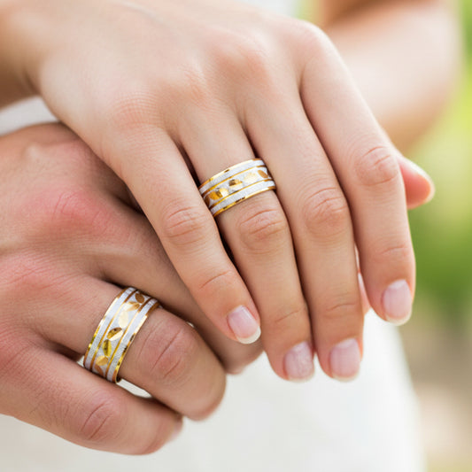 Manos de una pareja usando unas argollas rodinadas en oro amarillo de 18 quilates de Joyería Caracas.