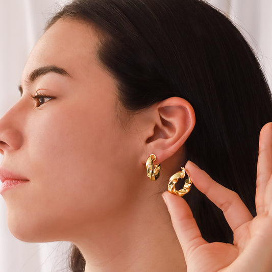 Oreja de mujer usando candongas en forma de melcocha de espiral en oro amarillo de 18 quilates de Joyería Caracas.