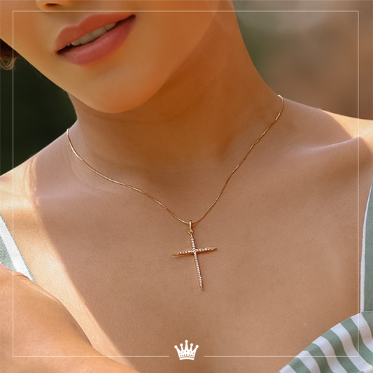 Cuello de mujer con cadena y dije de Cruz en oro amarillo de 18 quilates con cristales de color blanco, hecho en Joyería Caracas.