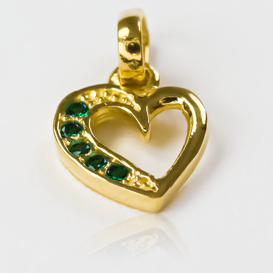 Dije Green heart cristal half JT de Joyería Caracas es el epitome de elegancia y lujo. Con su acabado en Oro 18K y cristal verde, cuenta con garantía de por vida.