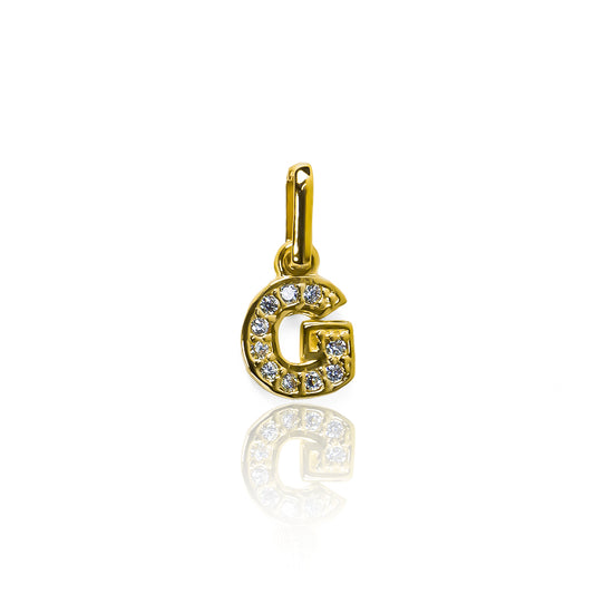 Dije de letra G está hecho de oro 18K y cuenta con un delicado cristal mini JT. Con su diseño exclusivo de Joyería Caracas y garantía para toda la vida.