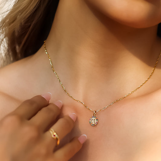 Cuello de mujer con cadena y dije de la Virgen Milagrosa en oro amarillo de 18 quilates con cristales de distintos colores, hecho en Joyería Caracas.