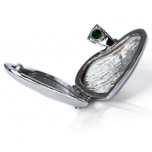 El Dije Relicario corazón de oro de 18K es una joya de la exclusiva Joyería Caracas. Con una preciosa esmeralda y diamantes, esta pieza elegante y sofisticada es una garantía de por vida. Luce con estilo y distinción con este símbolo de amor y lujo.