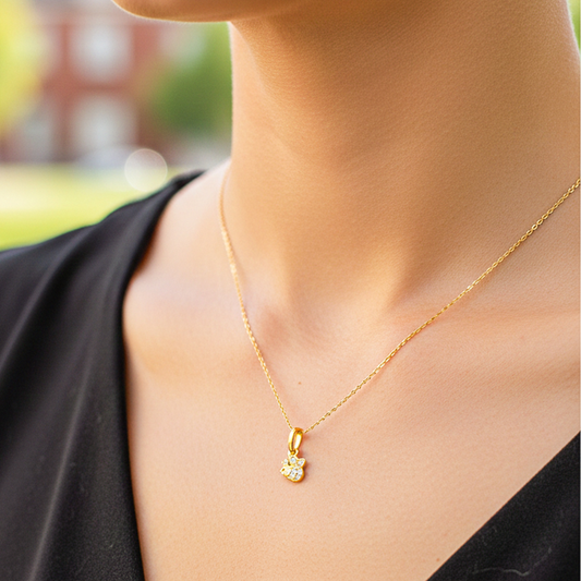 Cuello de modelo usando una cadena con un dije en forma de abeja en oro amarillo de 18 quilates con cristales de Joyería Caracas.