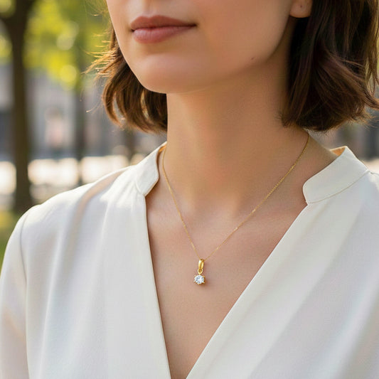 Cuello de modelo usando una cadena con un dije en oro amarillo de 18 quilates con cristal redondo de Joyería Caracas.