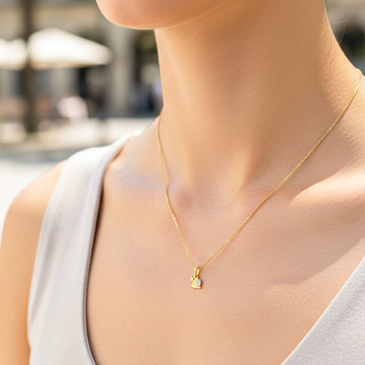 Cuello de modelo usando una cadena con un dije en forma de caracol en oro amarillo de 18 quilates con cristales de Joyería Caracas.