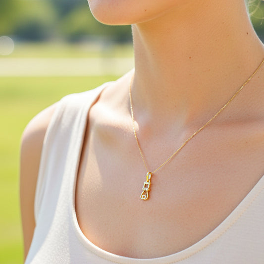 Cuello de modelo usando una cadena con un dije en forma de gato en oro amarillo de 18 quilates con cristales de Joyería Caracas.
