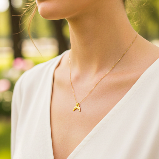 Cuello de modelo usando una cadena con un dije en forma de cola de sirena en oro amarillo de 18 quilates de Joyería Caracas.