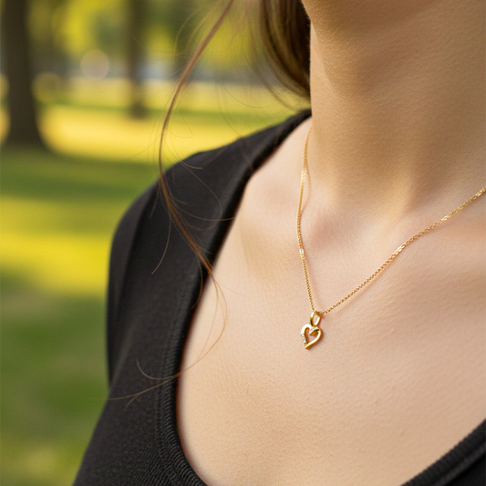 Cuello de modelo usando una cadena con un dije en forma de corazón en oro amarillo de 18 quilates con cristales de Joyería Caracas.