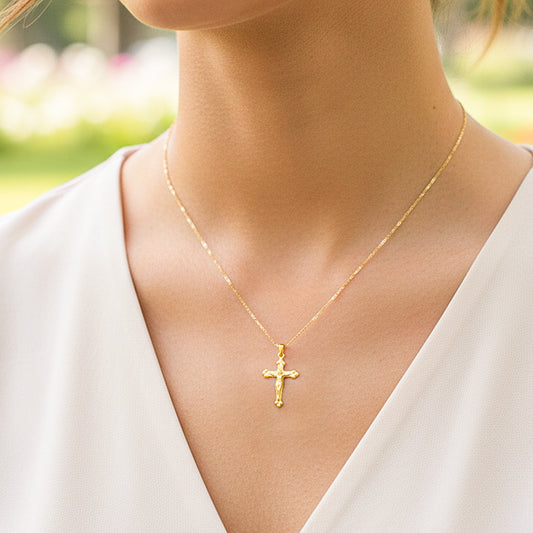 Cuello de modelo usando una cadena con un dije en forma de Cristo especial en oro amarillo de 18 quilates de Joyería Caracas.