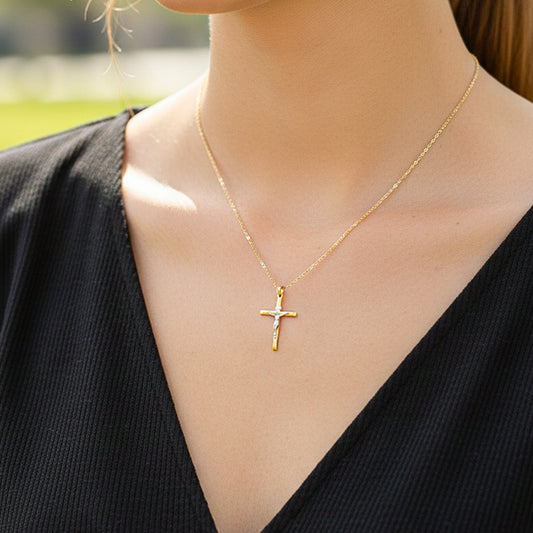 Cuello de modelo usando una cadena con un dije en forma de Cruz con Cristo en oro amarillo y blanco de 18 quilates de Joyería Caracas.