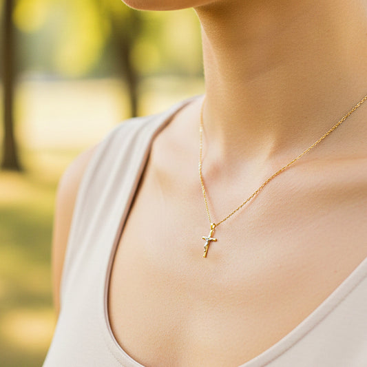 Cuello de modelo usando una cadena con un dije en forma de Cruz con Cristo en oro amarillo y blanco de 18 quilates de Joyería Caracas.