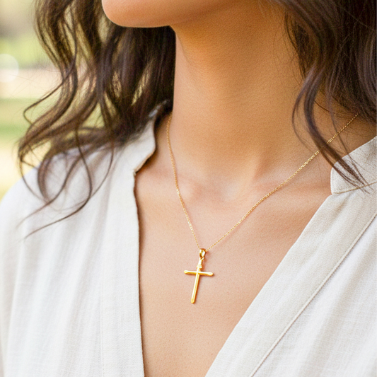 Cuello de modelo usando una cadena con un dije en forma de Cruz inri lisa en oro amarillo de 18 quilates de Joyería Caracas.