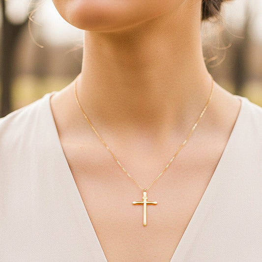 Cuello de modelo usando una cadena con un dije en forma de cruz lisa tubo en oro amarillo de 18 quilates de Joyería Caracas.