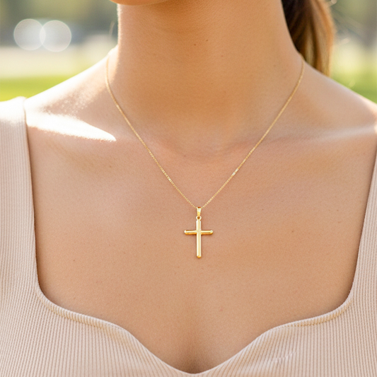 Cuello de modelo usando una cadena con un dije en forma de Cruz tubo lisa en oro amarillo de 18 quilates de Joyería Caracas.