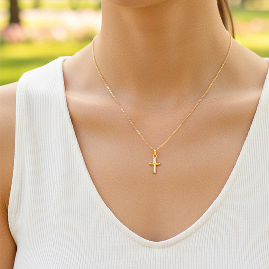 Cuello de modelo usando una cadena con un dije en forma de Cruz de tubo en oro amarillo de 18 quilates de Joyería Caracas.