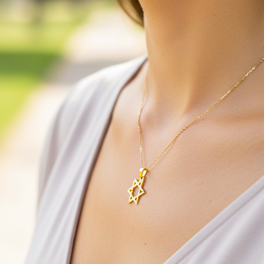Cuello de modelo usando una cadena con un dije en forma de Estrella de David en oro amarillo de 18 quilates de Joyería Caracas.