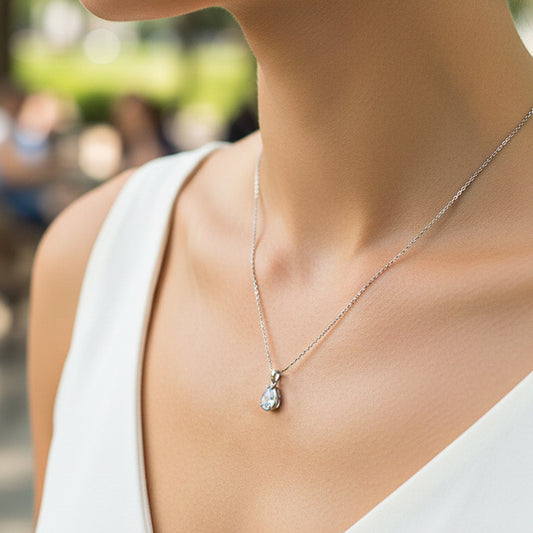 Cuello de modelo usando una cadena con un dije en forma de gota en oro blanco de 18 quilates con cristal de Joyería Caracas.