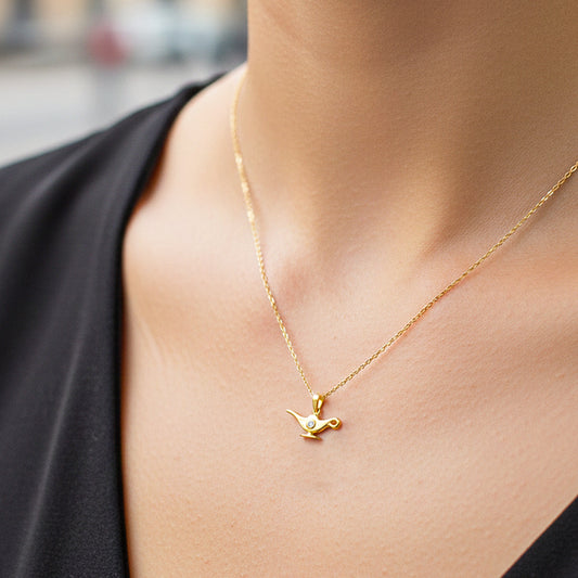 Cuello de modelo usando una cadena con un dije en forma de lámpara de enfermería en oro amarillo de 18 quilates con cristales de Joyería Caracas.