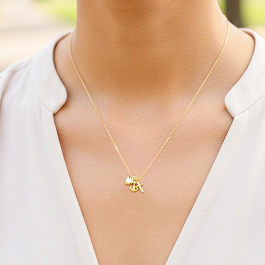 Cuello de modelo usando una cadena con un dije en forma de las tres gracias en oro amarillo de 18 quilates de Joyería Caracas.
