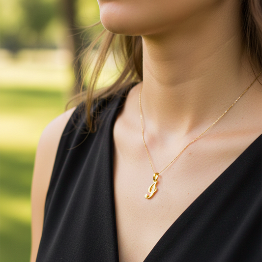 Cuello de modelo usando una cadena con un dije de la letra I cursiva en oro amarillo de 18 quilates de Joyería Caracas.