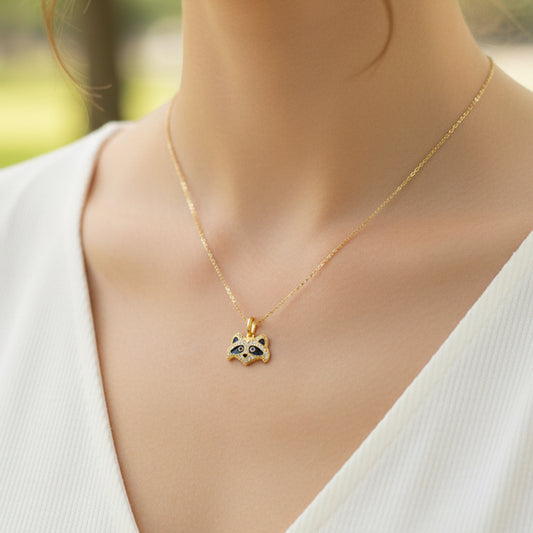 Cuello de modelo usando una cadena con un dije en forma de mapache en oro amarillo de 18 quilates con cristales y esmaltado de Joyería Caracas.