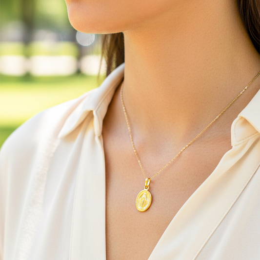 Cuello de modelo usando una cadena con un dije de la Virgen Milagrosa en oro amarillo de 18 quilates de Joyería Caracas.