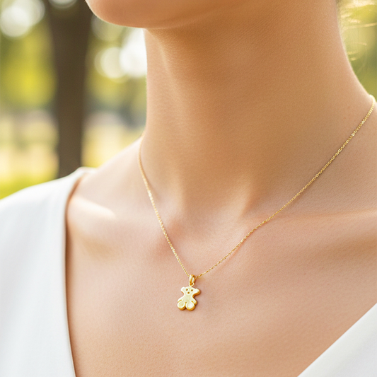 Cuello de modelo usando una cadena con un dije en forma de oso en oro amarillo de 18 quilates con cristales de Joyería Caracas.