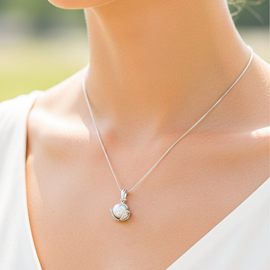 Cuello de modelo usando una cadena con un dije en forma de pétalos en oro amarillo de 18 quilates y con perla natural de Joyería Caracas.