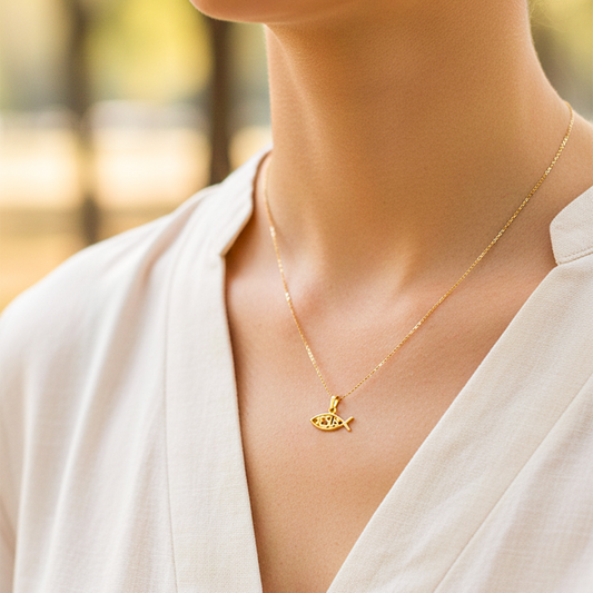 Cuello de modelo usando una cadena con un dije en forma de pez con la palabra Jesús en oro amarillo de 18 quilates de Joyería Caracas.