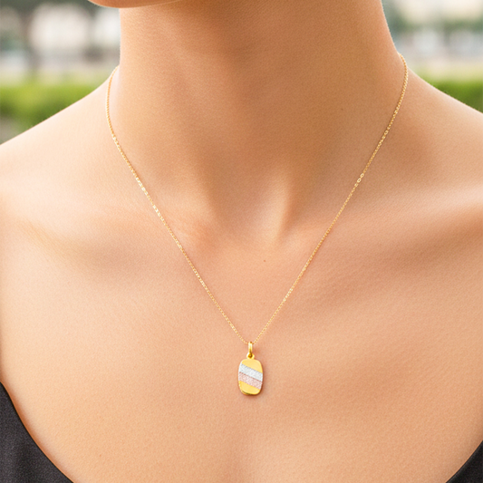 Cuello de modelo usando una cadena con un dije en forma de placa en oro amarillo, blanco y rosa de 18 quilates de Joyería Caracas.