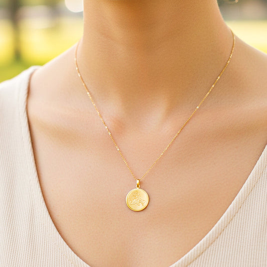 Cuello de modelo usando una cadena con un dije de placa redonda personalizable en oro amarillo de 18 quilates de Joyería Caracas.