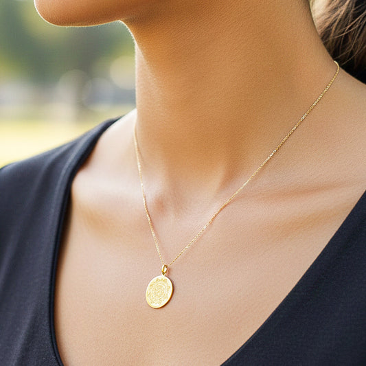 Cuello de modelo usando una cadena con un dije de placa redonda personalizable en oro amarillo de 18 quilates de Joyería Caracas.